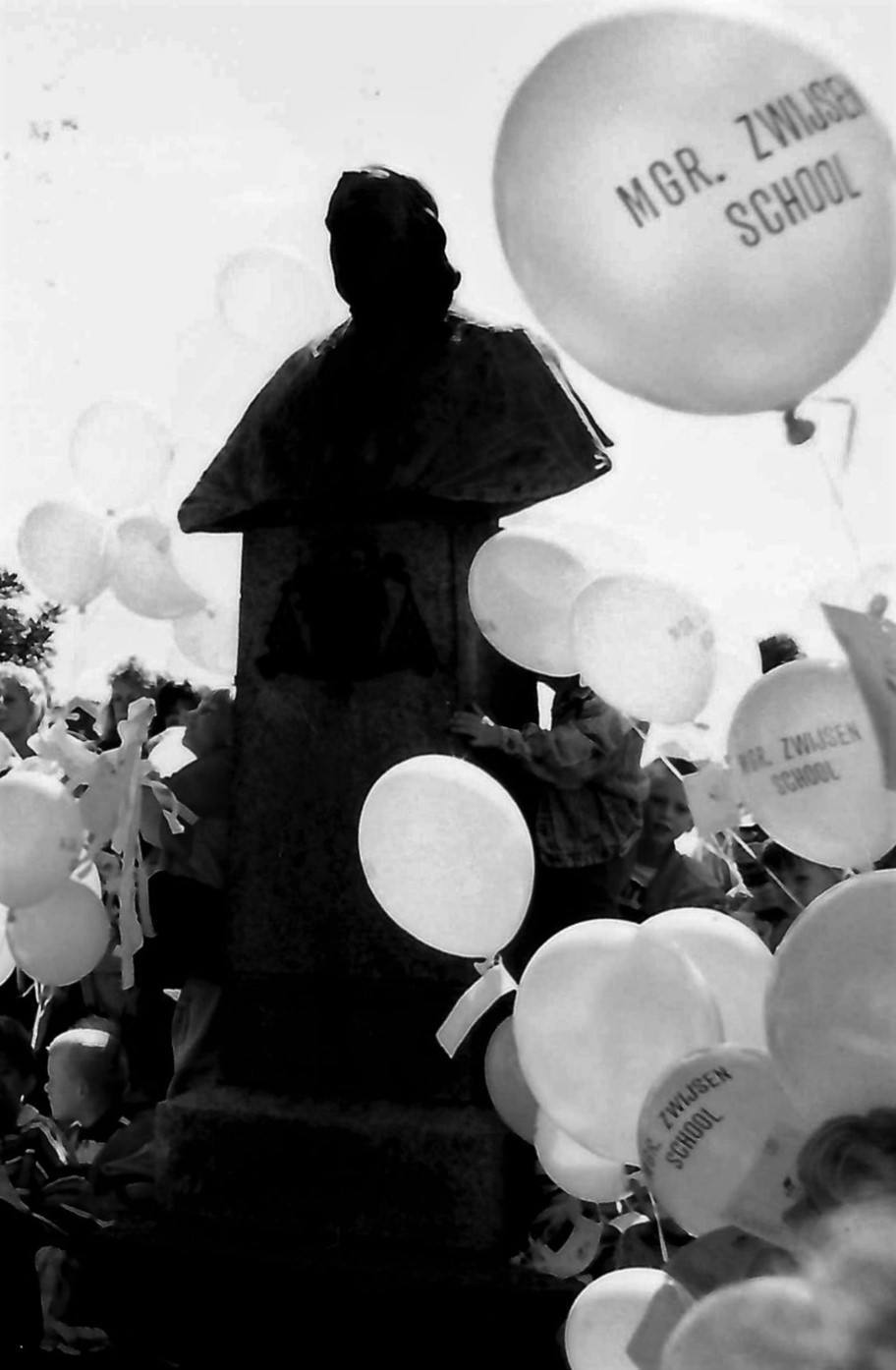 foto standbeeld en ballonnen met opschrift mgr. zwijsenschool