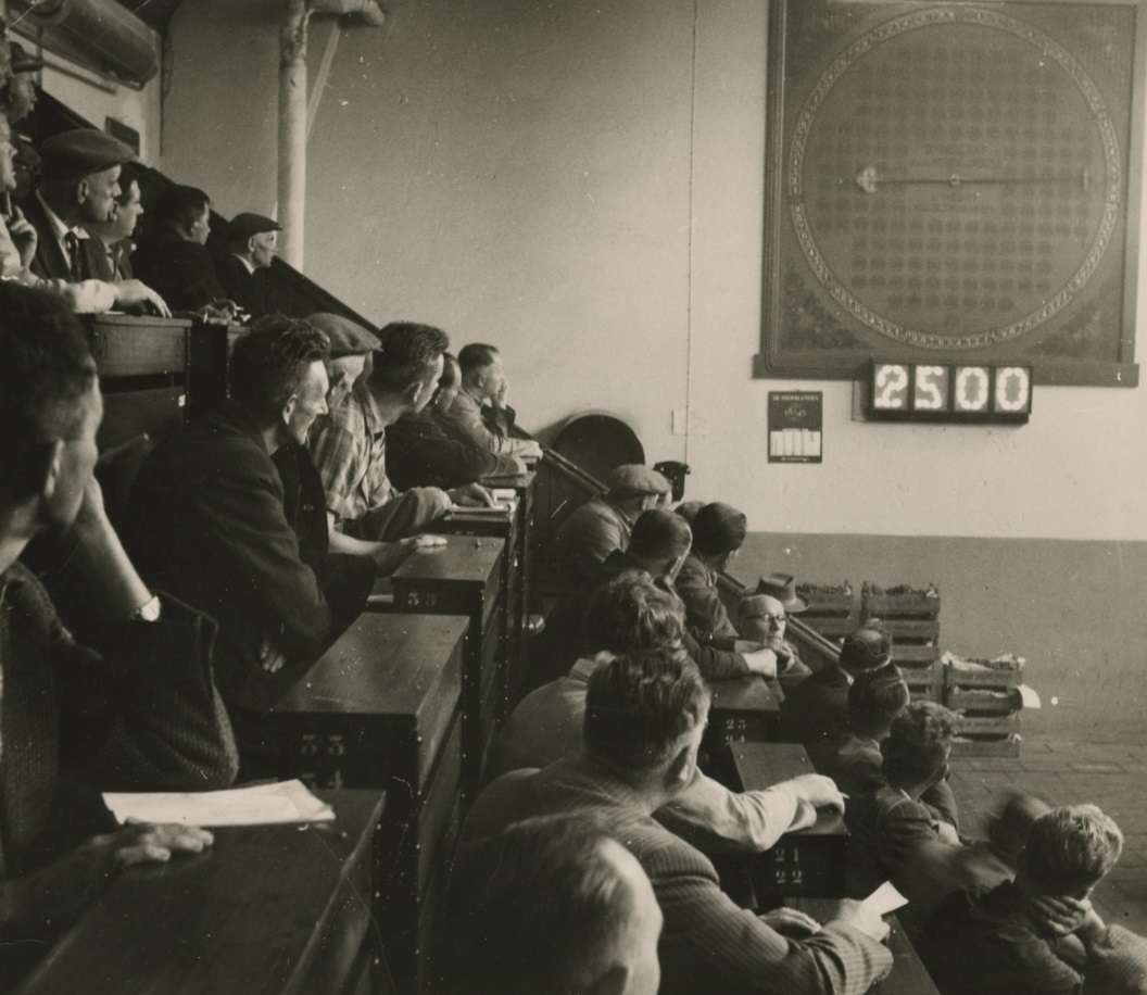 Mannen in mijnlokaal met grote veilingklok